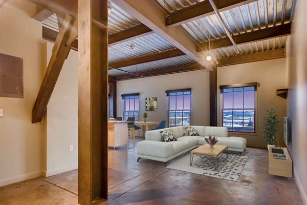 Spacious living room with exposed brick walls and modern design in Albers Mill Lofts Apartments