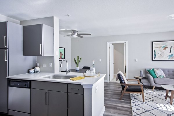 Modern kitchen with granite countertops and stainless steel appliances at Seven West at the Trails Apartments in Greystar's luxury community