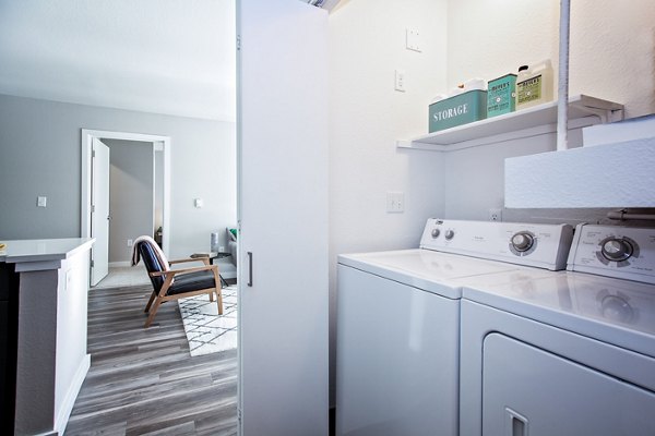 Laundry room with modern appliances at Seven West at the Trails Apartments