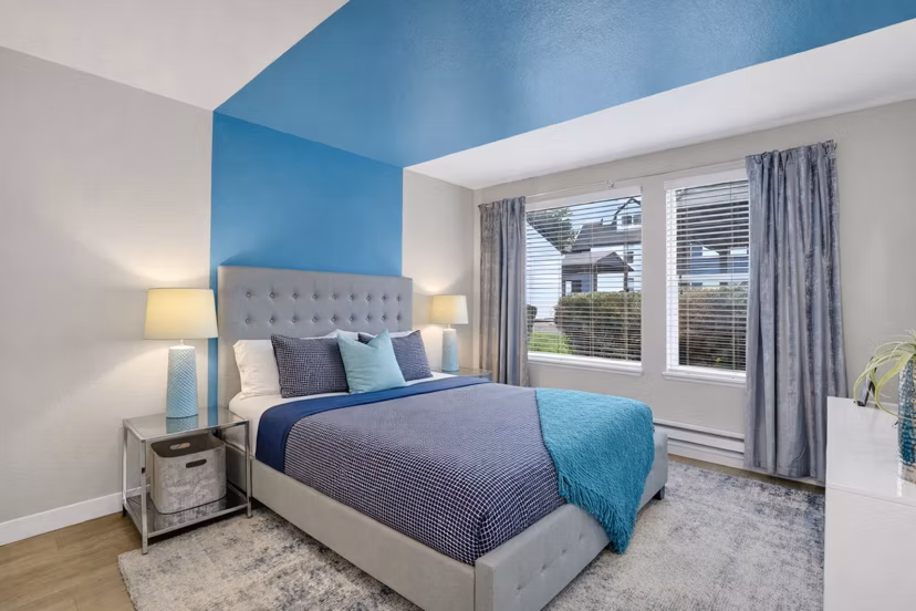 Cozy bedroom with modern decor at Rivercrest Meadows Apartments, featuring plush bedding and stylish lighting