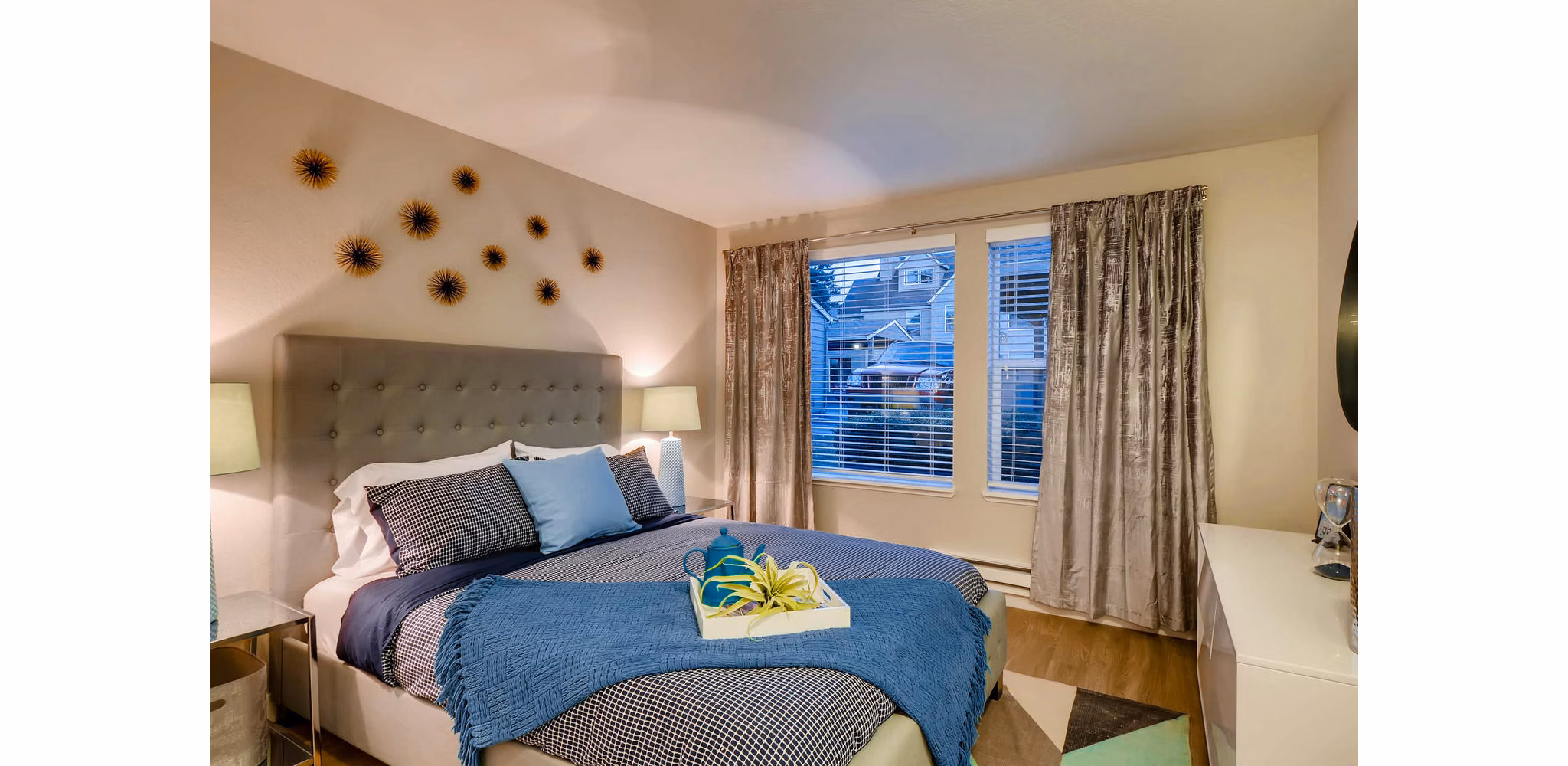 Cozy bedroom with modern decor at Rivercrest Meadows Apartments, featuring plush bedding and stylish lighting