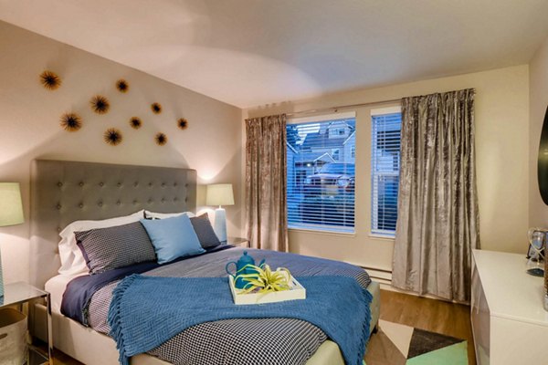 Cozy bedroom with modern decor at Rivercrest Meadows Apartments, featuring plush bedding and stylish lighting