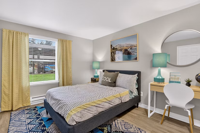 Cozy bedroom with a large window and stylish decor at Rivercrest Meadows Apartments