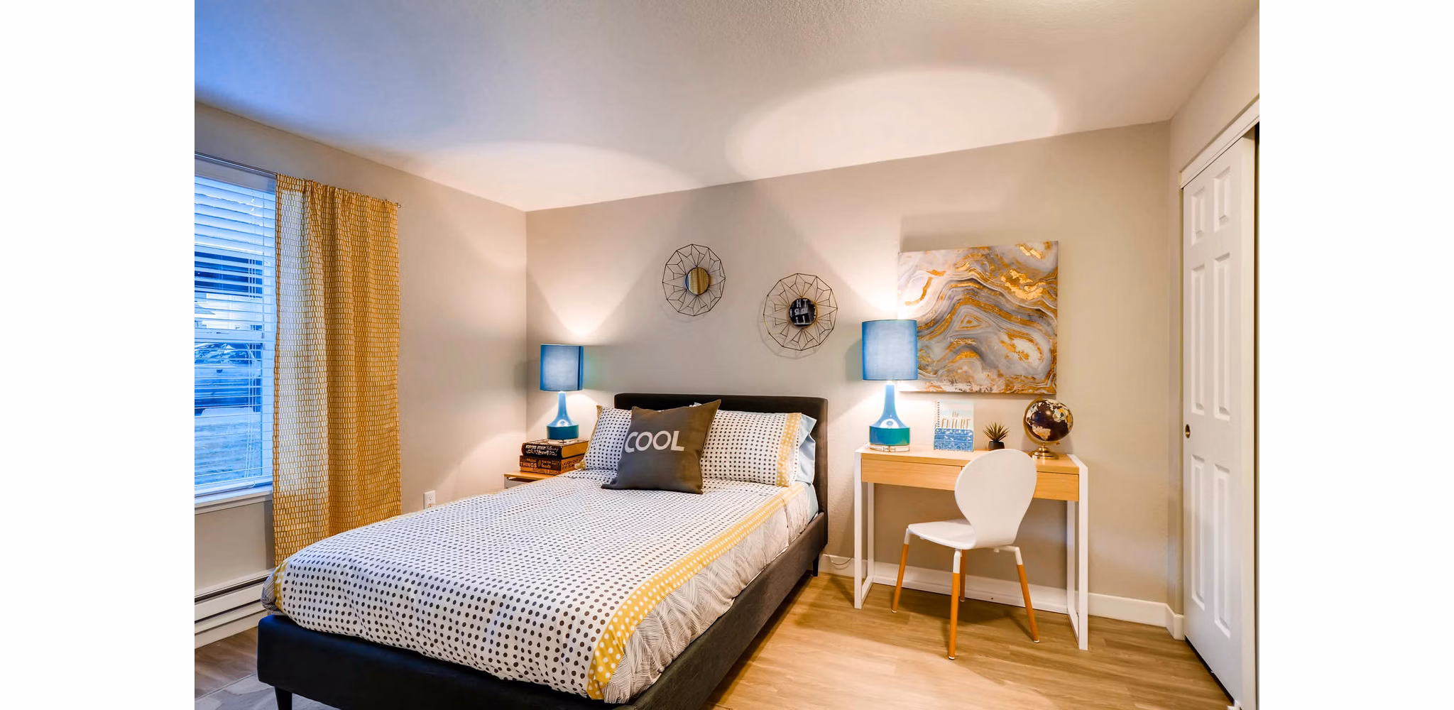 Cozy bedroom with a large window and stylish decor at Rivercrest Meadows Apartments