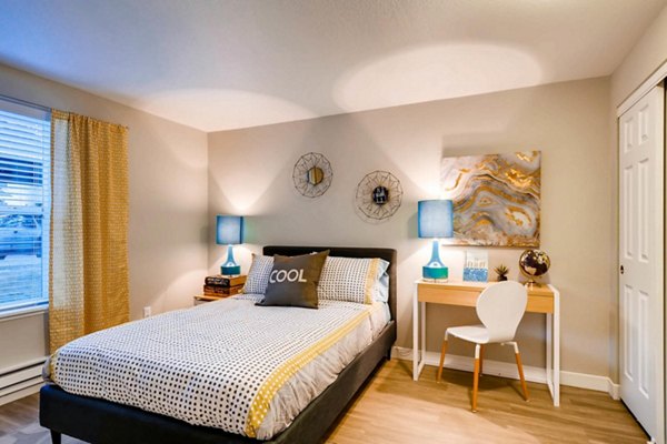 Cozy bedroom with a large window and stylish decor at Rivercrest Meadows Apartments