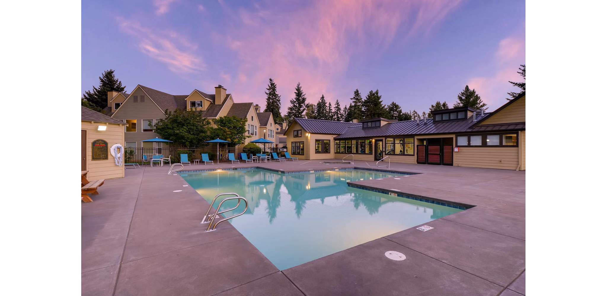 Resort-style pool at Rivercrest Meadows Apartments with lush landscaping and loungers, perfect for luxury living and relaxation