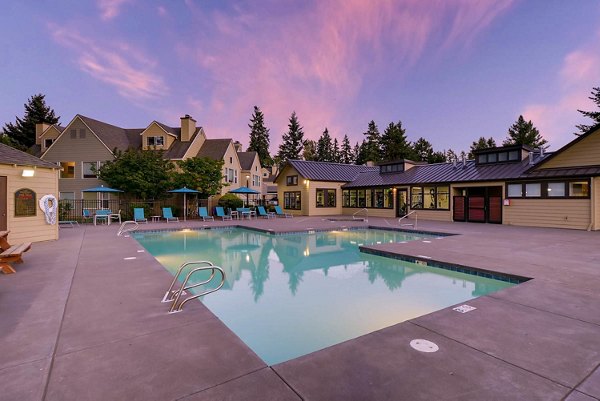 Resort-style pool at Rivercrest Meadows Apartments with lush landscaping and loungers, perfect for luxury living and relaxation