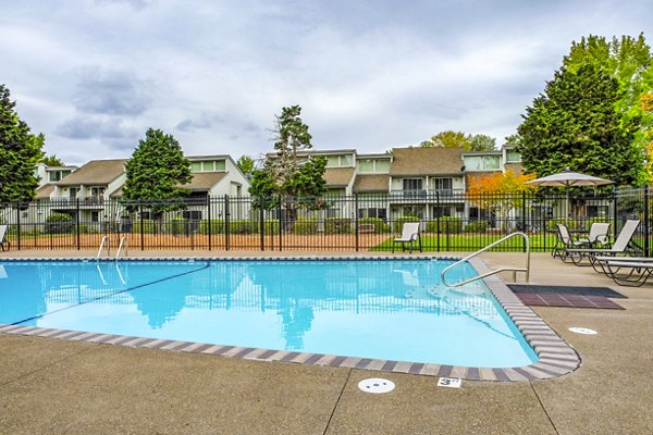 Resort-style swimming pool with lounge chairs at Meadowlawn Apartments offering luxury living