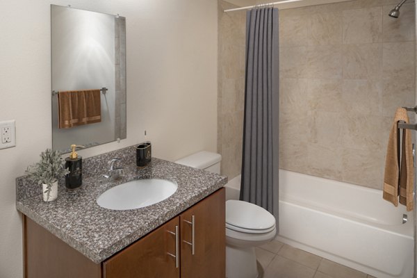 Modern bathroom with sleek fixtures and large mirror at The Felix Apartments