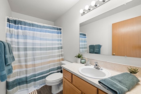 Modern bathroom with sleek fixtures and marble countertops at Highland Hills Apartments