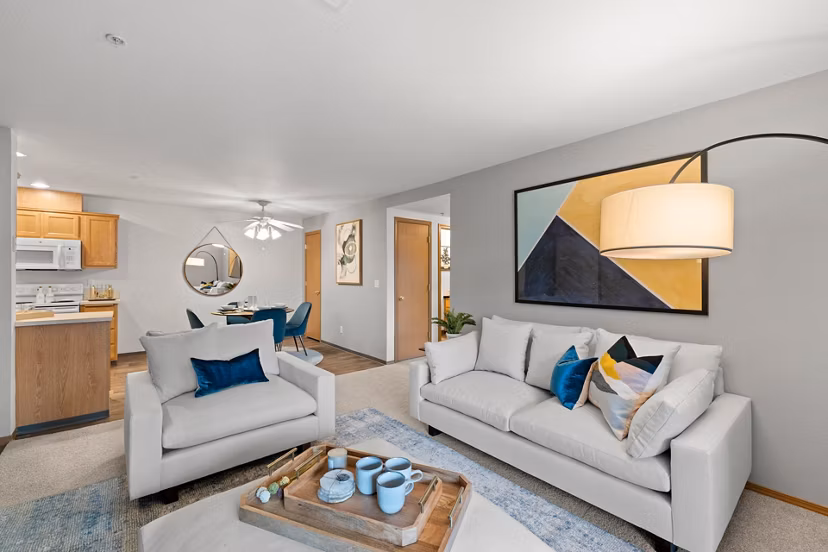 Spacious living room with modern furnishings in Highland Hills Apartments, featuring large windows and stylish decor