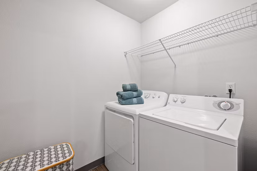 Laundry room with modern machines and ample folding space at Highland Hills Apartments