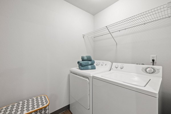 Laundry room with modern machines and ample folding space at Highland Hills Apartments