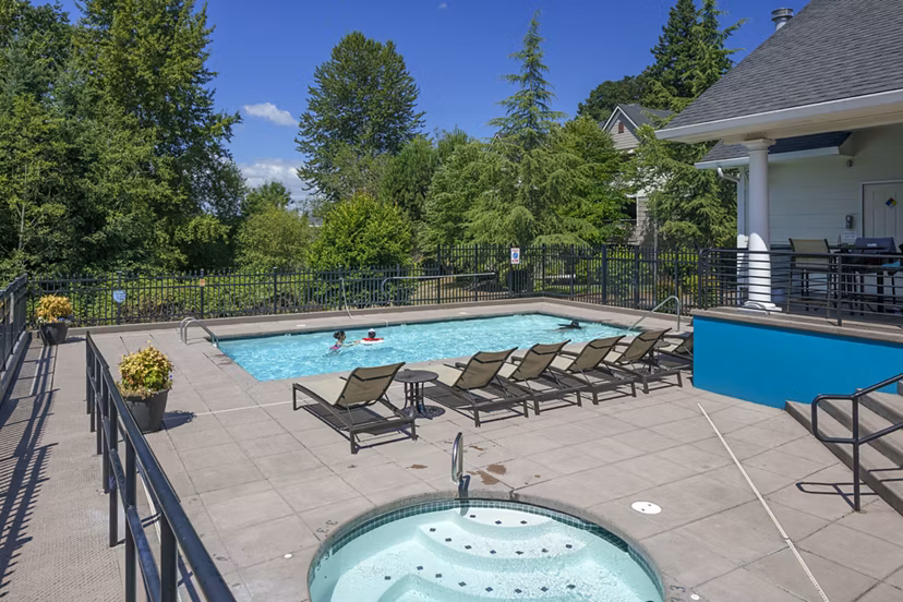 Luxurious outdoor pool area at Highland Hills Apartments featuring comfortable lounge seating and lush landscaping