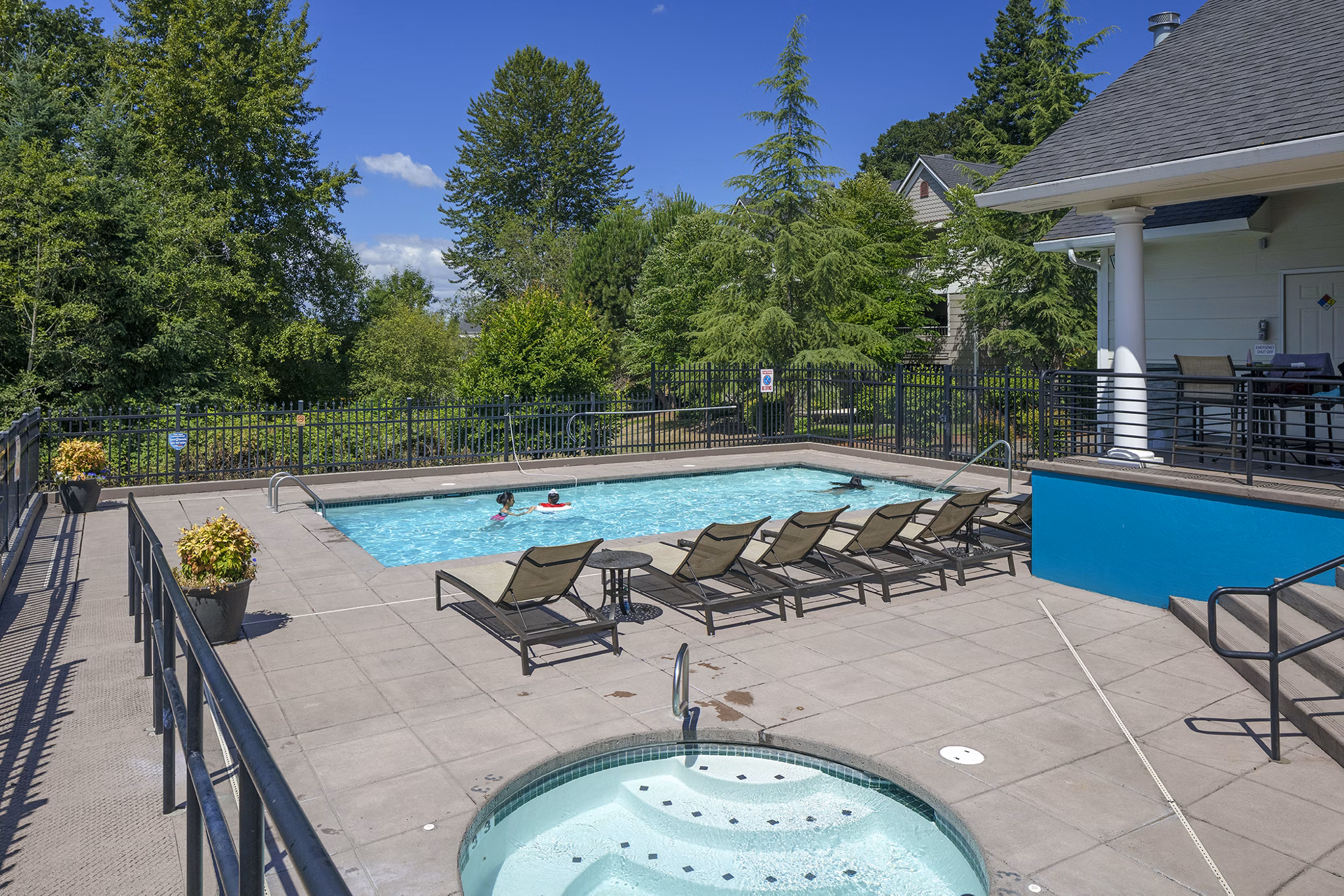 Luxurious outdoor pool area at Highland Hills Apartments featuring comfortable lounge seating and lush landscaping