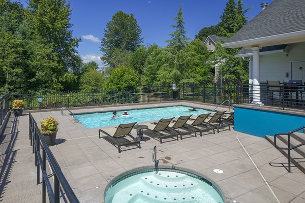 Luxurious outdoor pool area at Highland Hills Apartments featuring comfortable lounge seating and lush landscaping