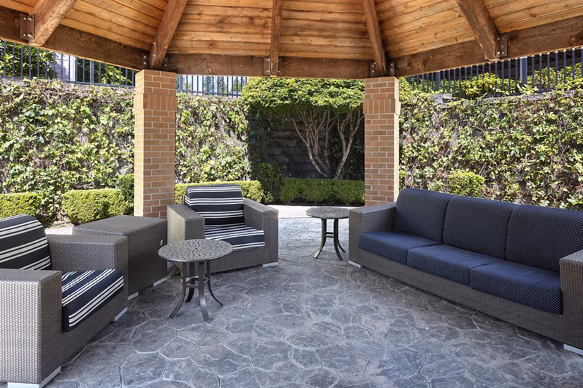 Patio area at Highland Hills Apartments featuring outdoor seating and lush landscaping
