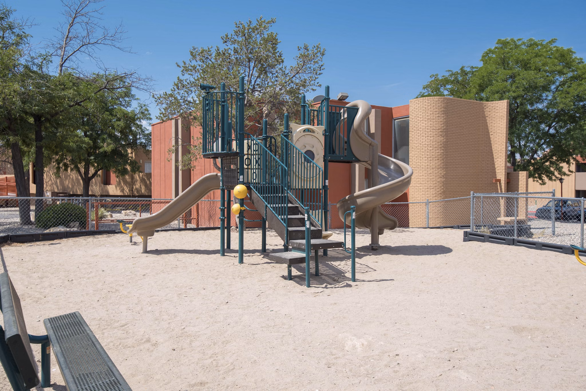 Playground area with slides and swings at Desert Creek Apartments offering family-friendly outdoor activities