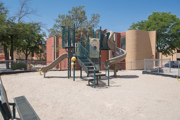 Playground area with slides and swings at Desert Creek Apartments offering family-friendly outdoor activities