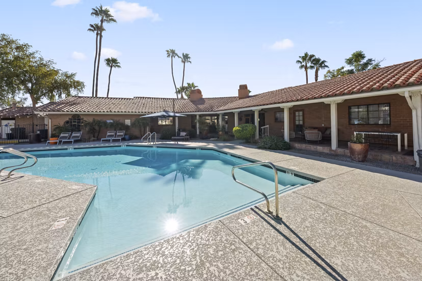 1000 Genoa Lakes Apartments: Luxurious pool area with lounge chairs and umbrellas for relaxation