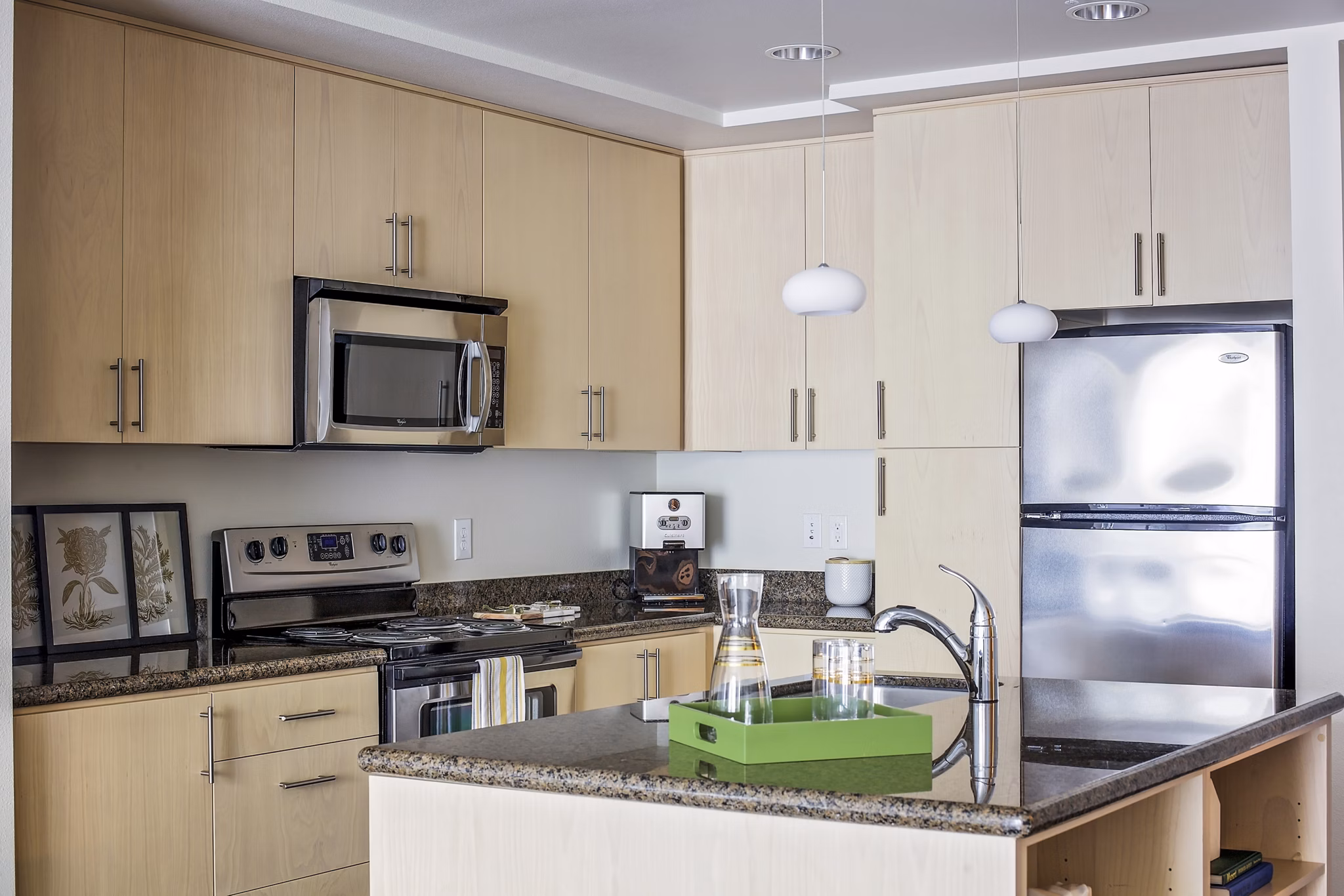 Modern kitchen with stainless steel appliances and quartz countertops in Enso Apartments