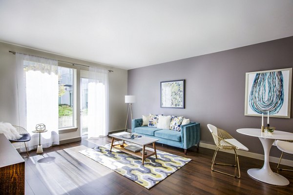 Modern living room with sleek furniture and ample natural light at Enso Apartments