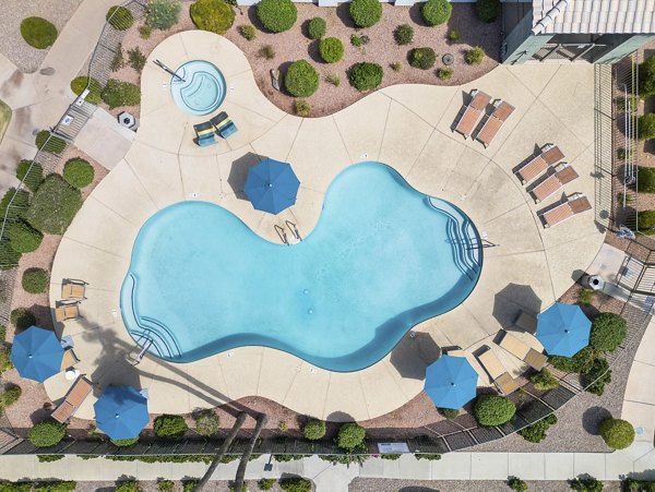 Resort-style pool at Palm Court Apartments with lush landscaping and luxurious lounging areas