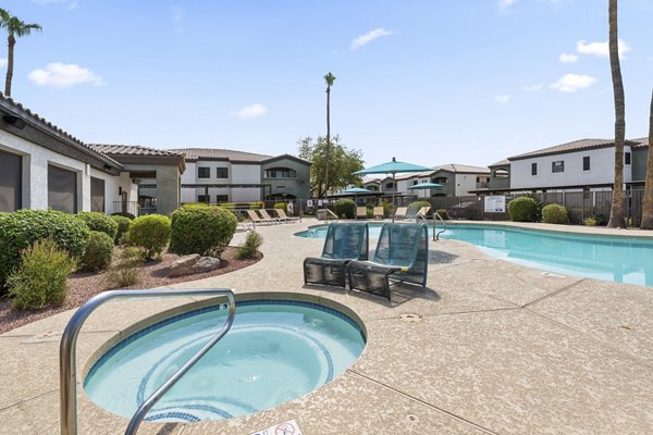 Outdoor pool surrounded by lush landscaping at Palm Court Apartments