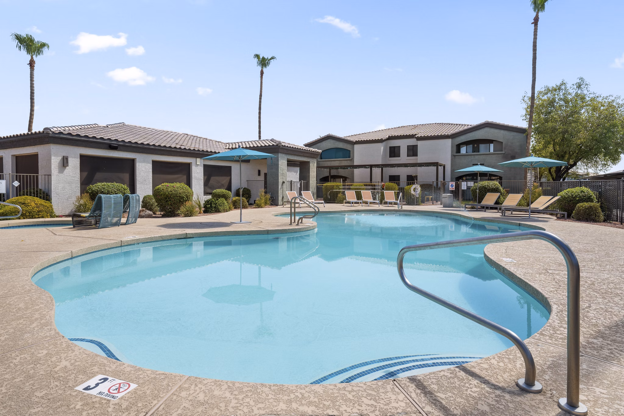 Palm Court Apartments: Resort-style pool with lounging areas