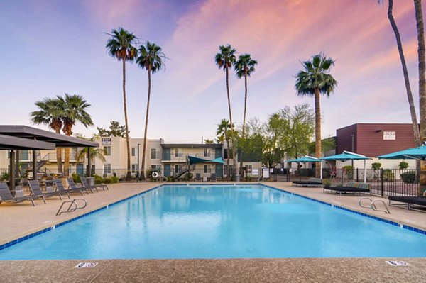 Resort-style pool at Scottsdale Gateway Apartments with lounge chairs and palm trees