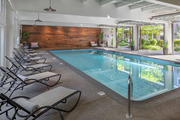 Poolside relaxation at Canyon Park Apartments: Luxury pool with lounge chairs and greenery, providing a serene retreat for residents