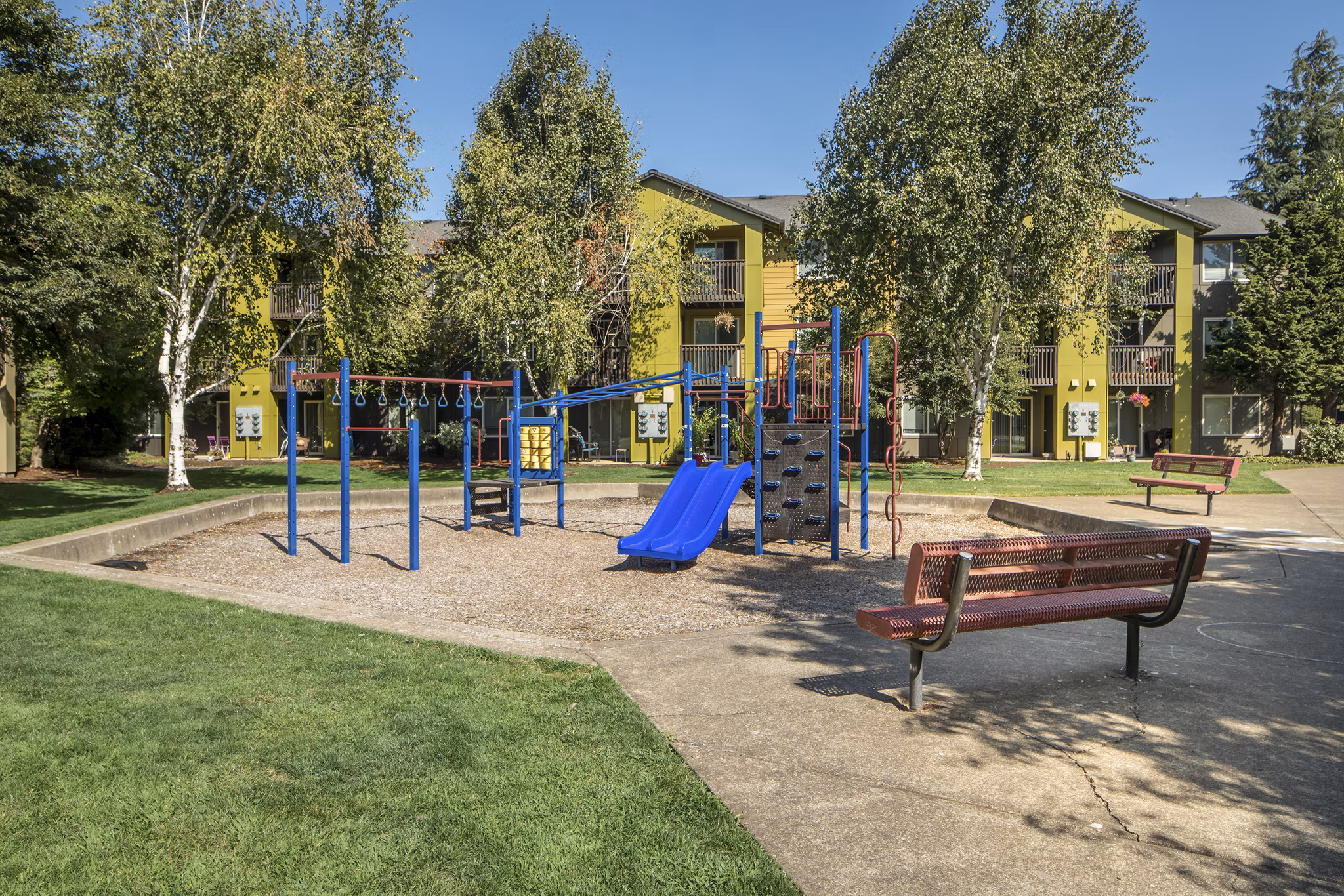 Modern playground featuring slides and swings at Crescent Park Apartments, luxury living with family-friendly amenities