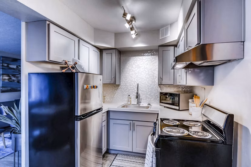 Modern kitchen with stainless steel appliances and island in Park Plaza Apartments luxury living