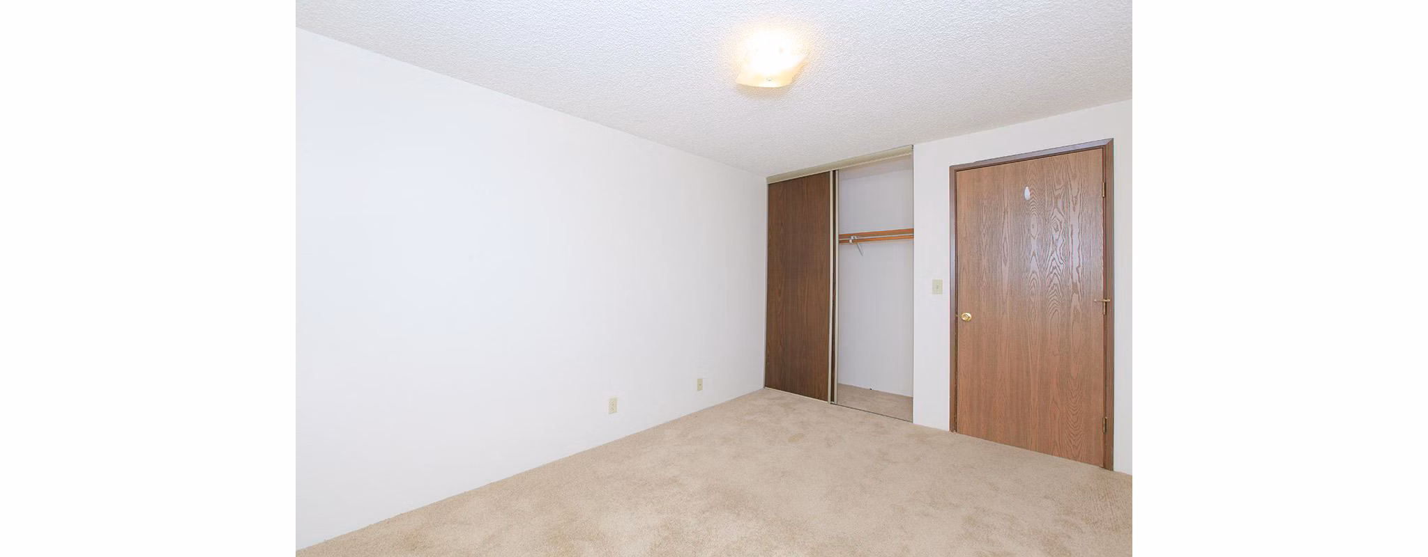 Cozy bedroom with ample natural light at Redwood Park Apartments
