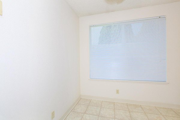 Cozy bedroom with elegant design at Redwood Park Apartments, featuring ample natural light and modern decor