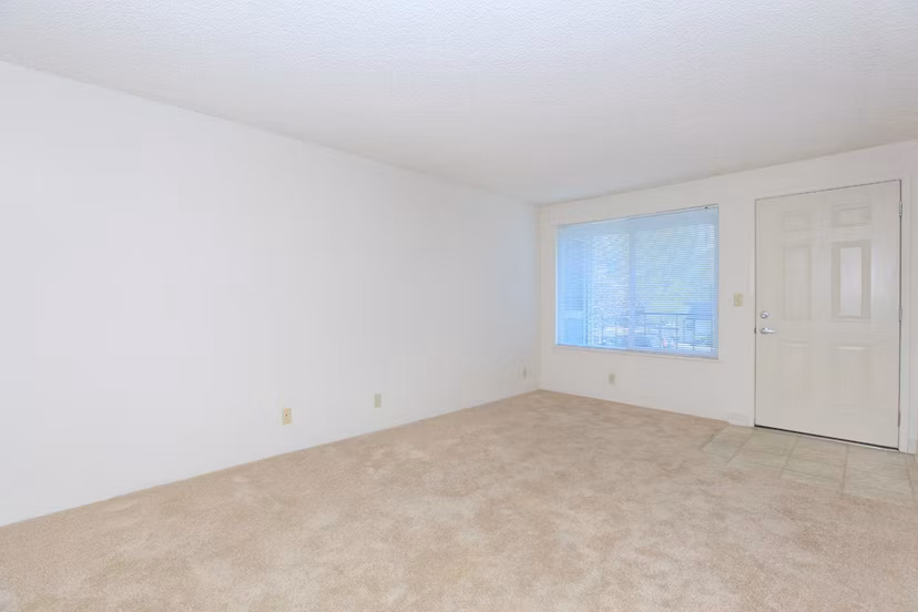 Spacious living room with modern furnishings and large windows in Redwood Park Apartments