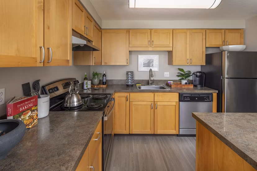 Modern kitchen featuring stainless steel appliances and granite countertops in Sorrento Bluff Apartments