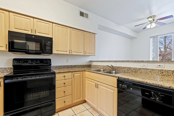Modern kitchen with stainless steel appliances at Logger Creek at Parkcenter Apartments