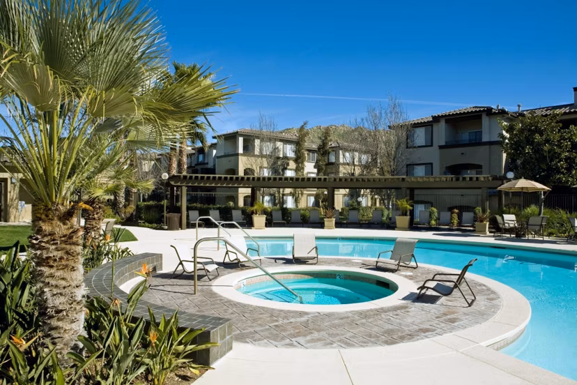Serene outdoor pool area at Castlerock Apartments with lounge chairs and lush landscaping
