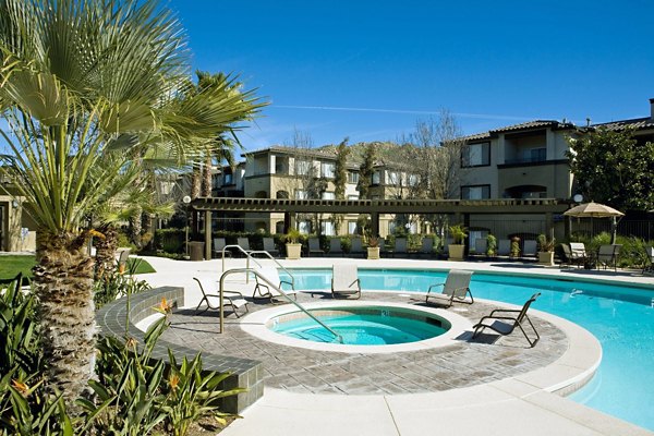 Serene outdoor pool area at Castlerock Apartments with lounge chairs and lush landscaping