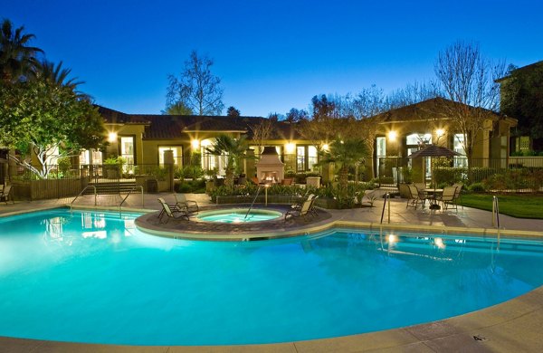 Outdoor pool with lounging chairs at Castlerock Apartments offering relaxation and recreation