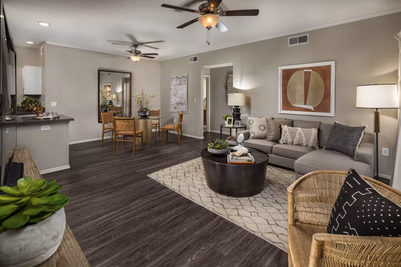 Spacious living room with modern decor and large windows in Colonnade Apartments