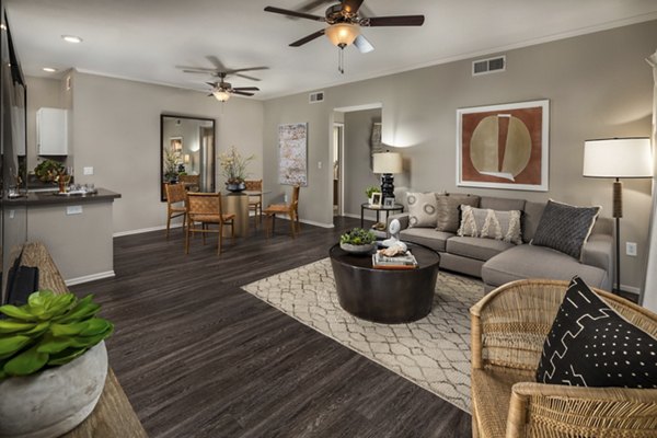 Spacious living room with modern decor and large windows in Colonnade Apartments