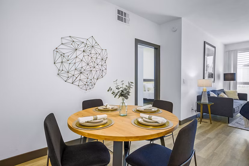 Dining room featuring elegant chandelier and modern furnishings at Enclave Apartments, luxurious living option in vibrant urban setting