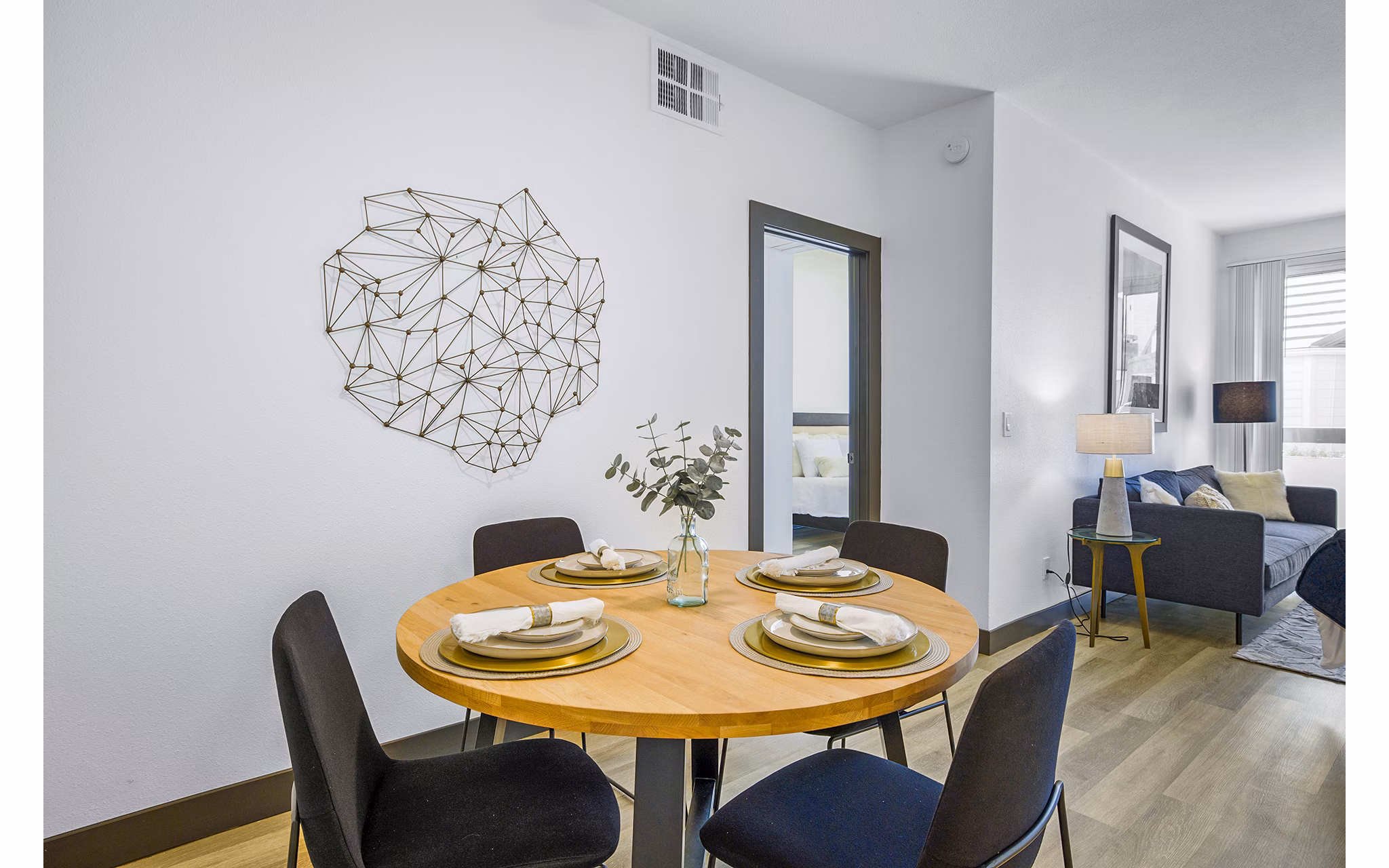 Dining room featuring elegant chandelier and modern furnishings at Enclave Apartments, luxurious living option in vibrant urban setting