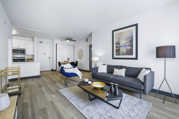 Bright living room with modern furniture and large windows in Enclave Apartments