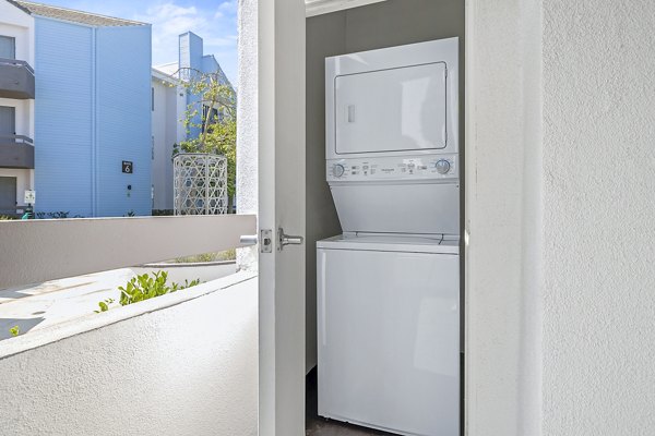 Laundry room with modern appliances at Enclave Apartments, luxury living by Greystar