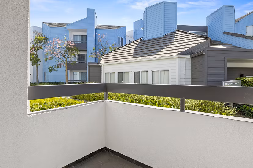 Private patio with outdoor seating at Enclave Apartments offering scenic views