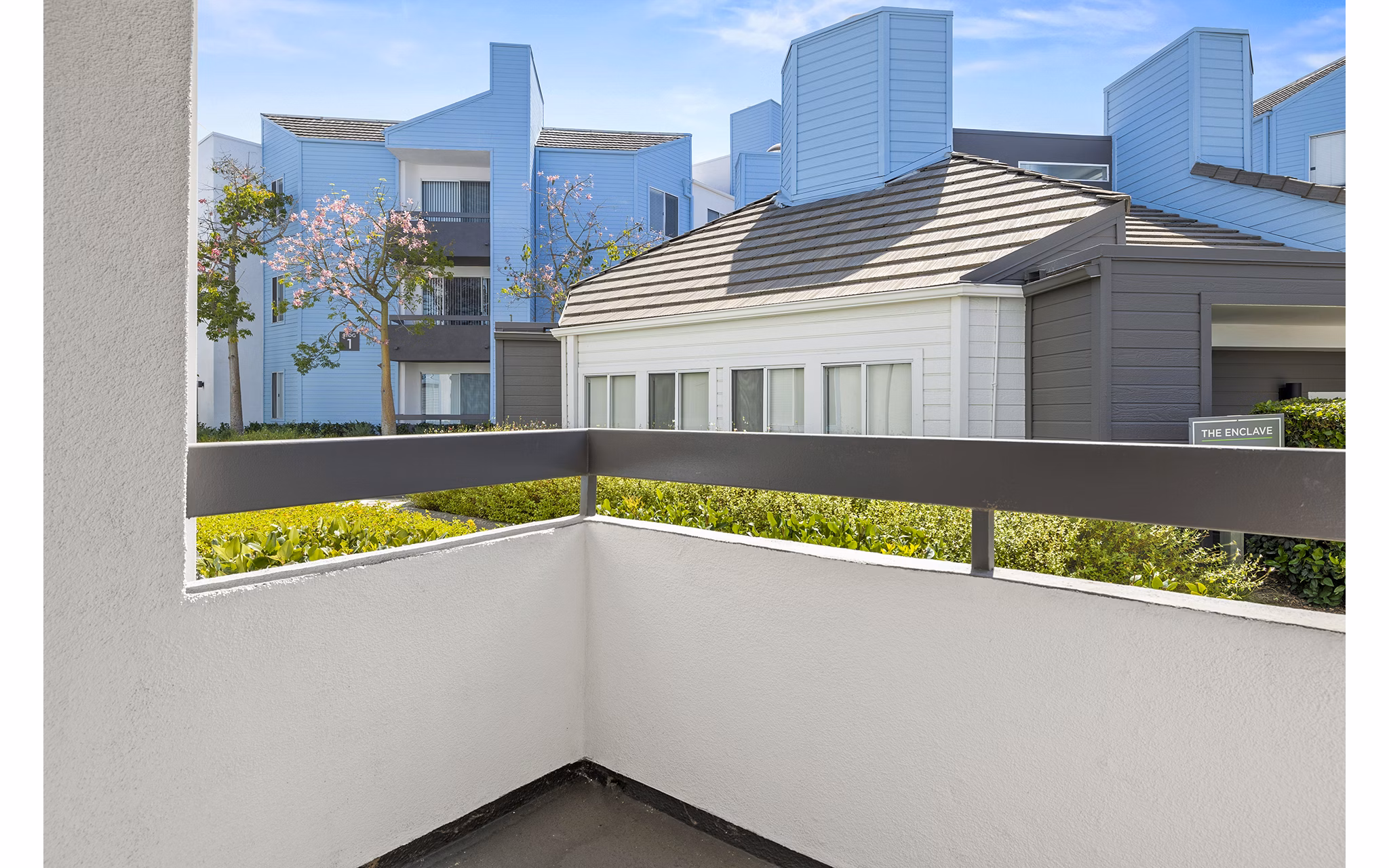 Private patio with outdoor seating at Enclave Apartments offering scenic views