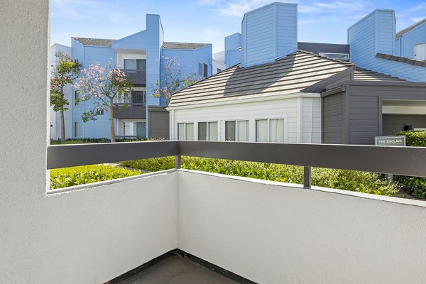 Private patio with outdoor seating at Enclave Apartments offering scenic views